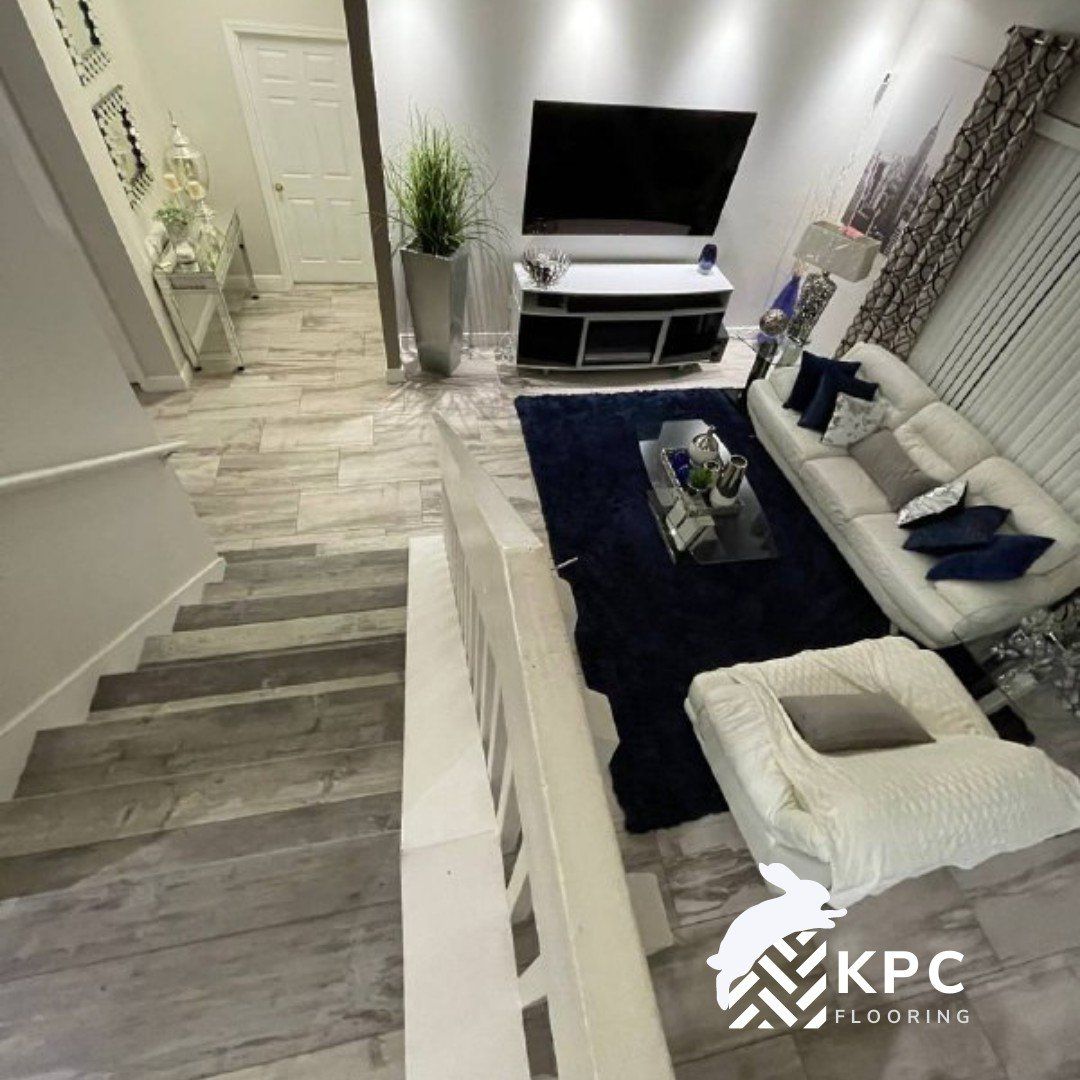 Gray wood-look vinyl plank flooring on a staircase that goes down to a living room